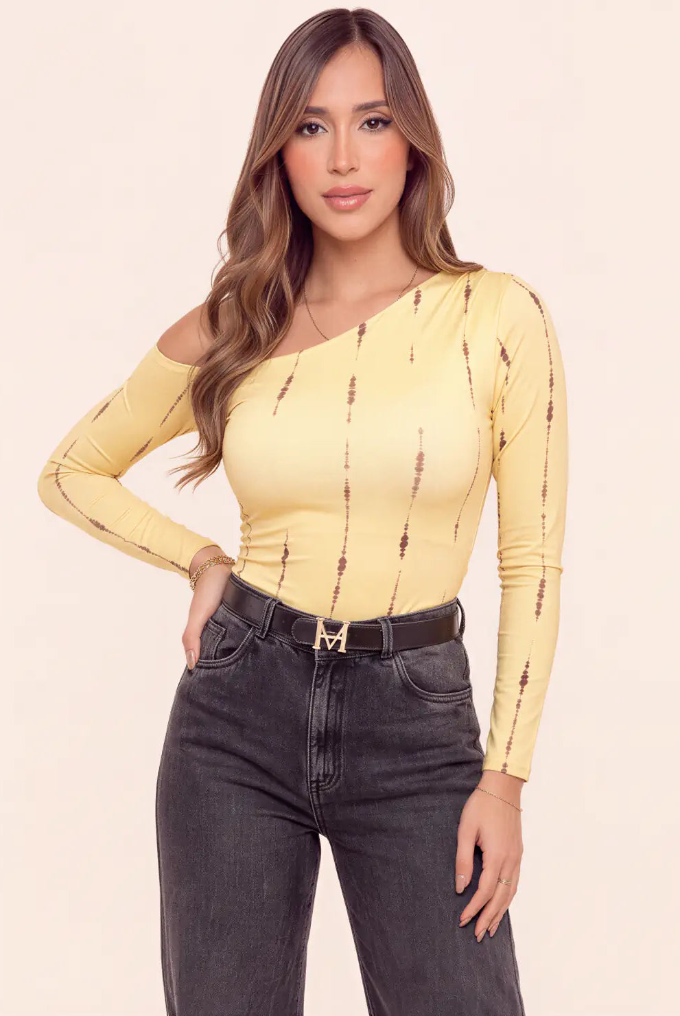 Modelo luciendo body amarillo asimétrico para mujer con manga larga, hombro descubierto y estampado de líneas verticales café de Tienda Coral.
