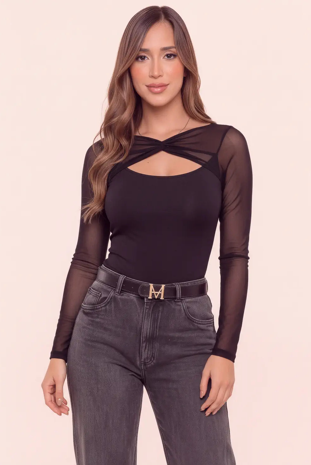Body negro para mujer con escote cruzado, abertura frontal y mangas largas en mesh semitransparente, combinado con jean gris.