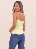 Vista posterior de blusa amarilla pastel de tirantes delgados, espalda descubierta con escote redondeado y costuras verticales, de Coral.