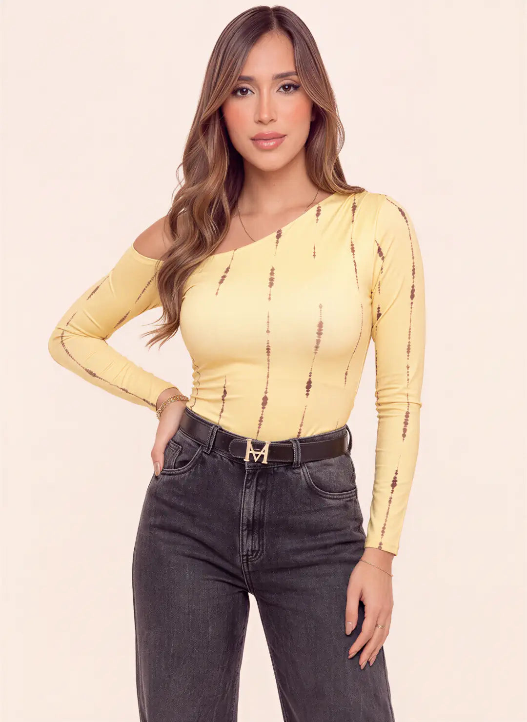 Modelo luciendo body amarillo asimétrico para mujer con manga larga, hombro descubierto y estampado de líneas verticales café de Tienda Coral.