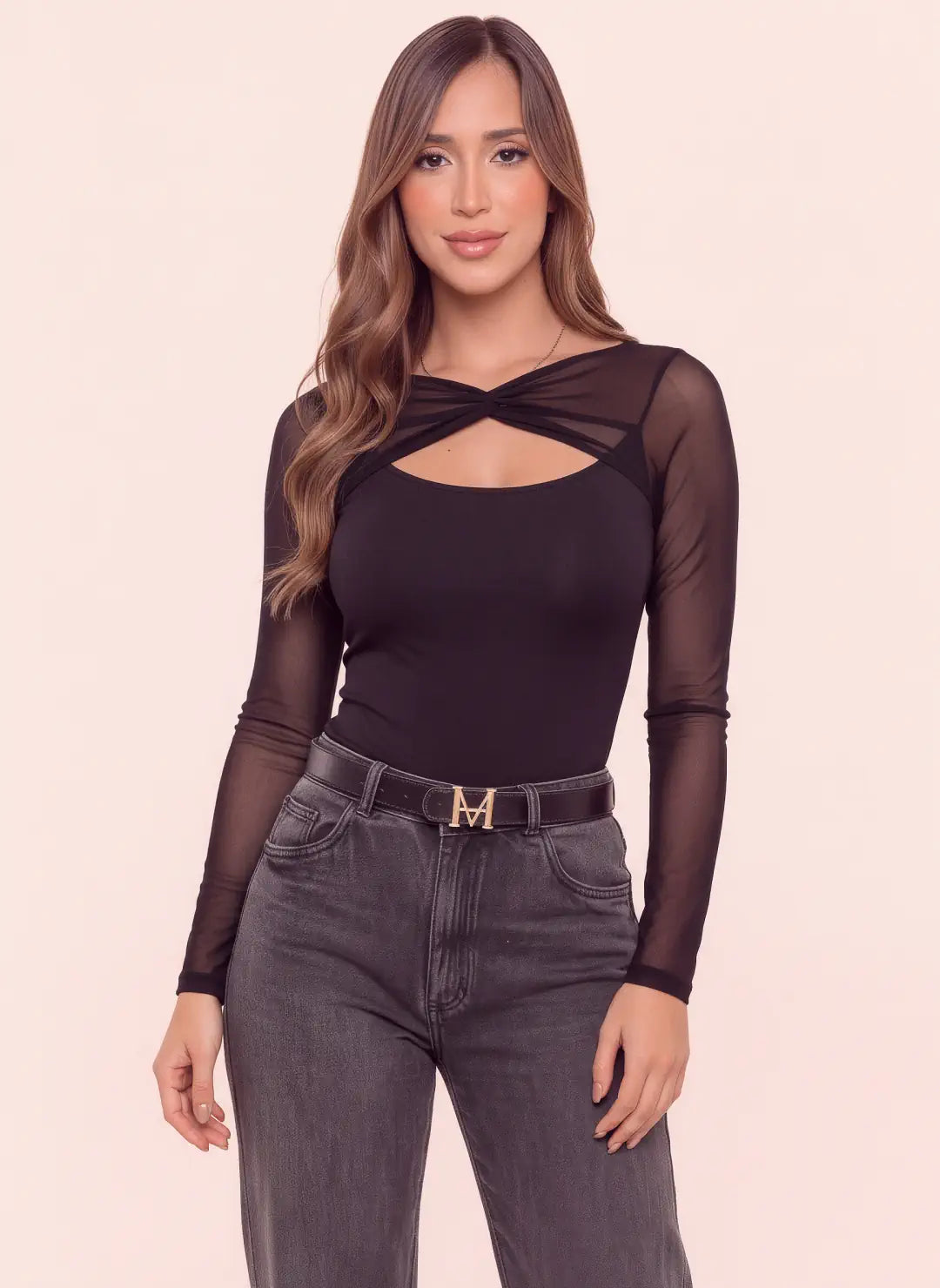 Body negro para mujer con escote cruzado, abertura frontal y mangas largas en mesh semitransparente, combinado con jean gris.